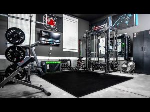 Modernt och organiserat hemmagym med smart gymutrustning i ett garage.